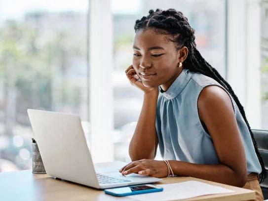 A manager working at a laptop in an office